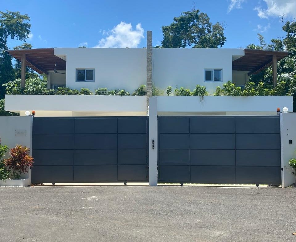 Casa moderna blanca con gran puerta metálica