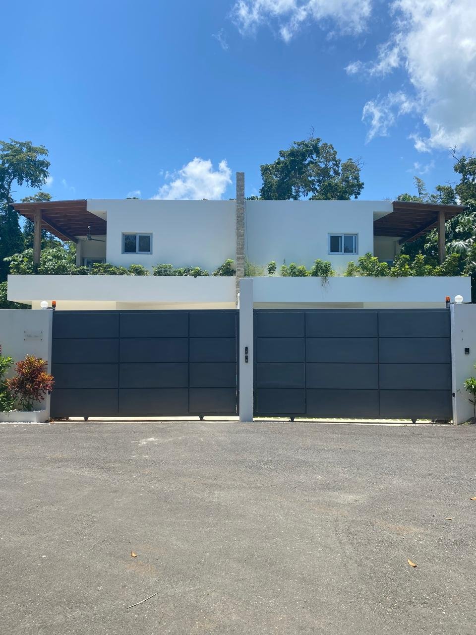Casa moderna blanca con gran puerta metálica