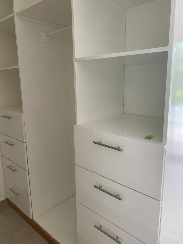 Armario blanco empotrado con estantes y cajones