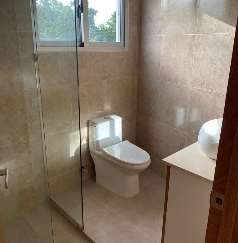 Baño moderno con ducha de cristal y ventana