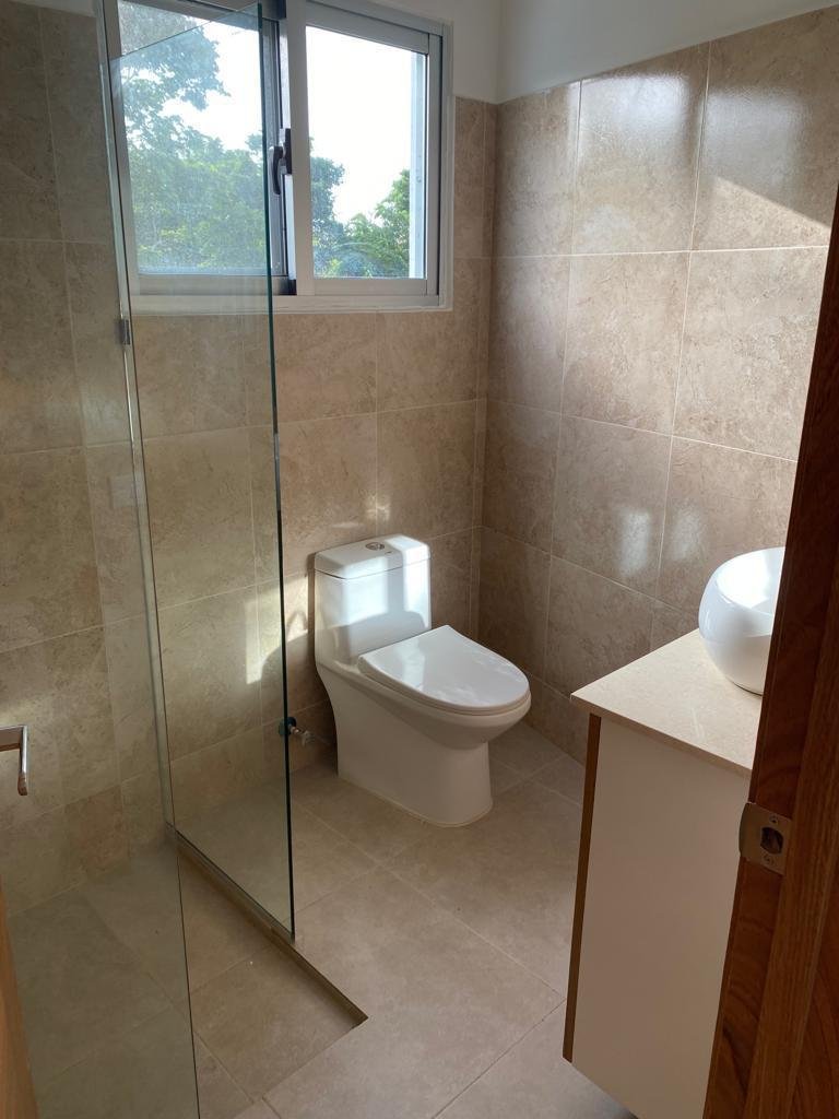 Baño moderno con ducha de cristal y ventana
