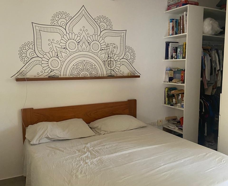 Dormitorio con cama doble y mandala en pared