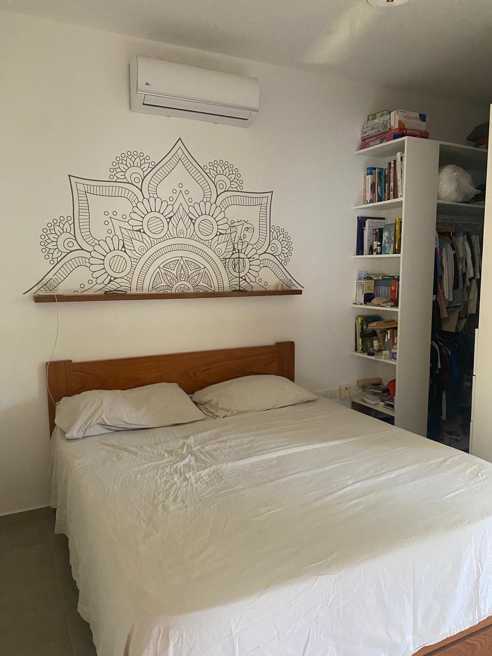 Dormitorio con cama doble y mandala en pared