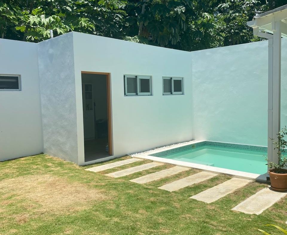 Casa moderna blanca con pequeña piscina y jardín