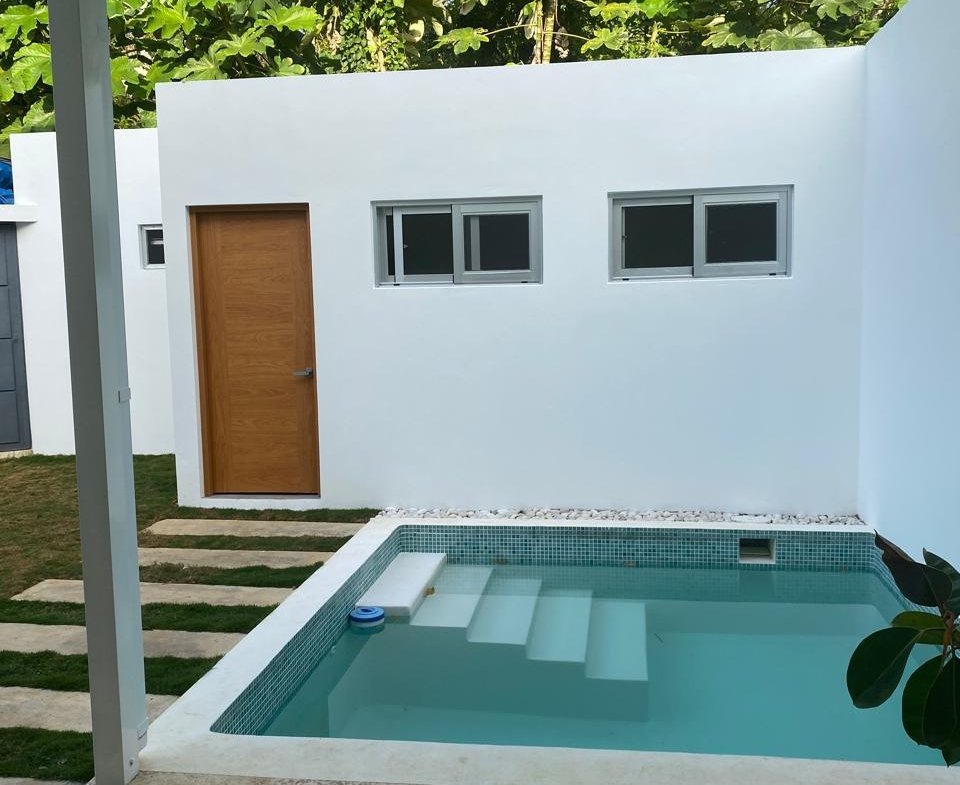 Pequeña piscina moderna en patio con paredes blancas