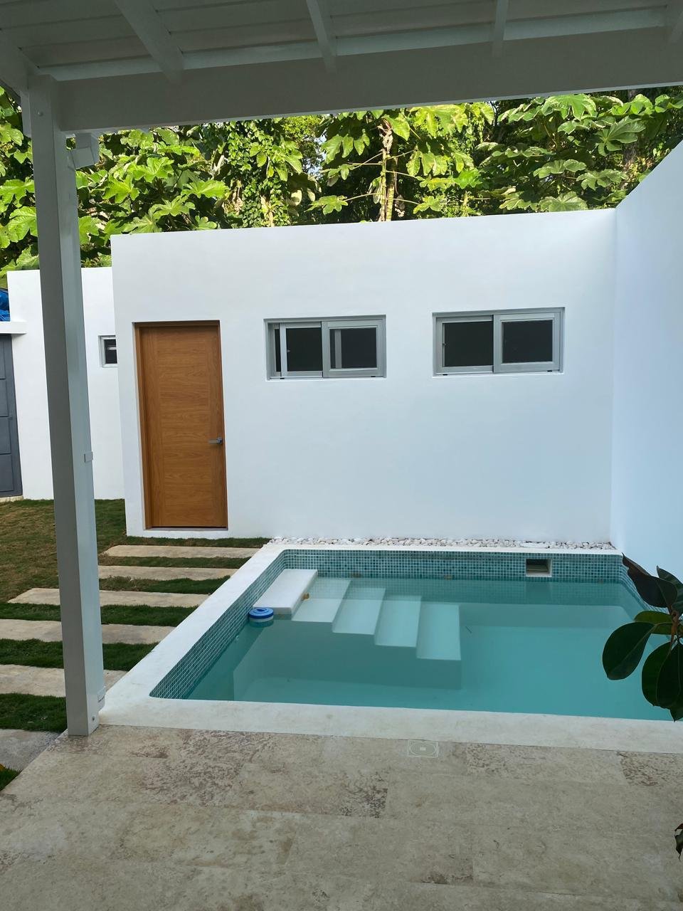 Pequeña piscina moderna en patio con paredes blancas