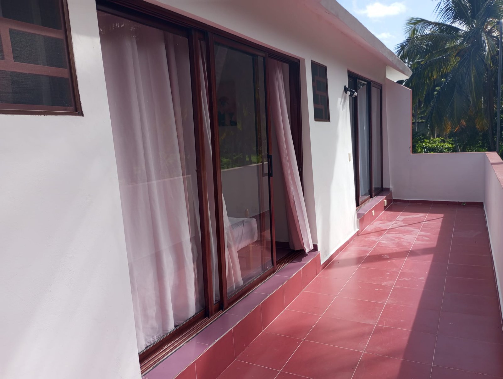 Villa en limon (11) Terraza con suelo rojo y puertas correderas