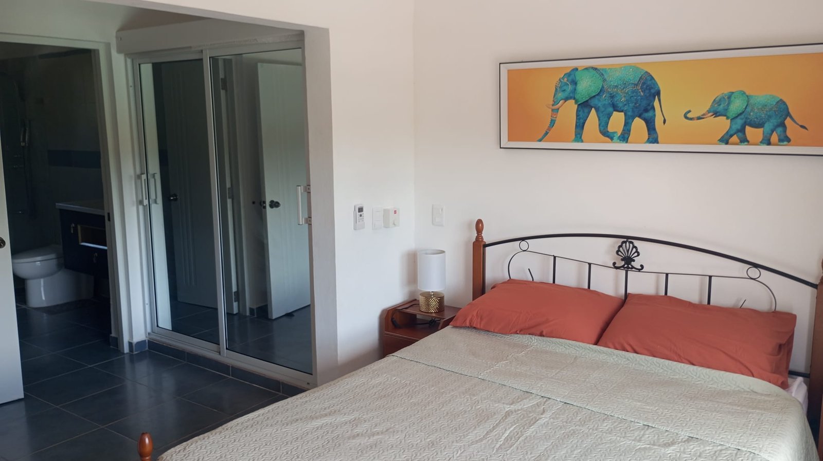 Villa en limon (2) Dormitorio moderno con cama doble y cuadro de elefantes