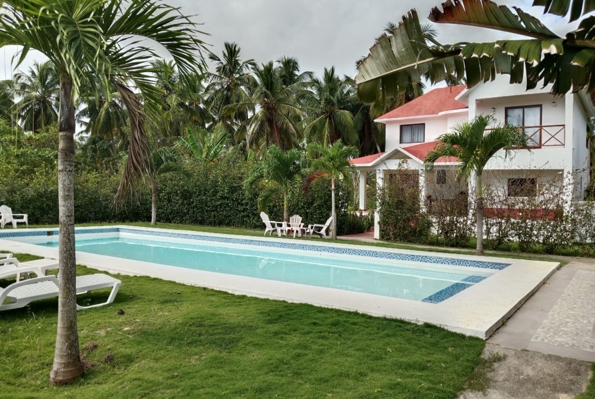 Casa tropical con piscina y palmeras