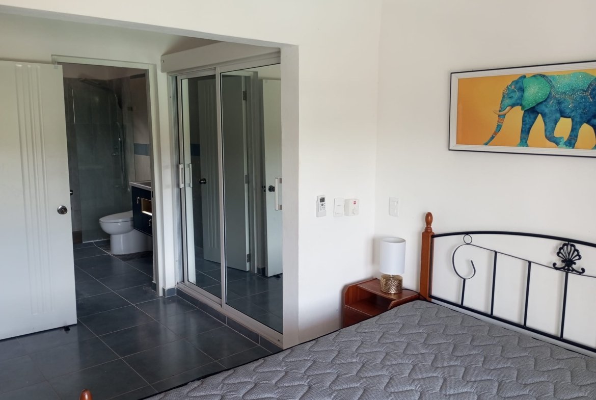 Dormitorio moderno con baño y armario espejo
