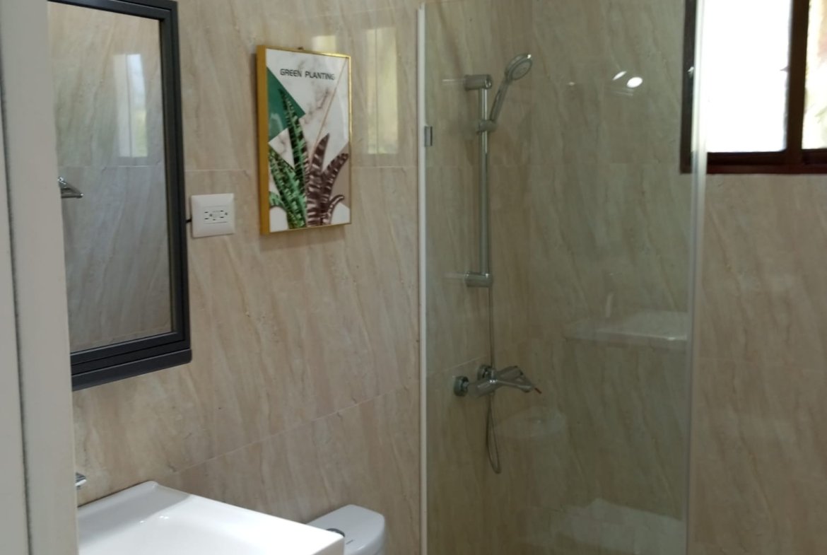 Baño moderno con ducha de cristal y lavabo