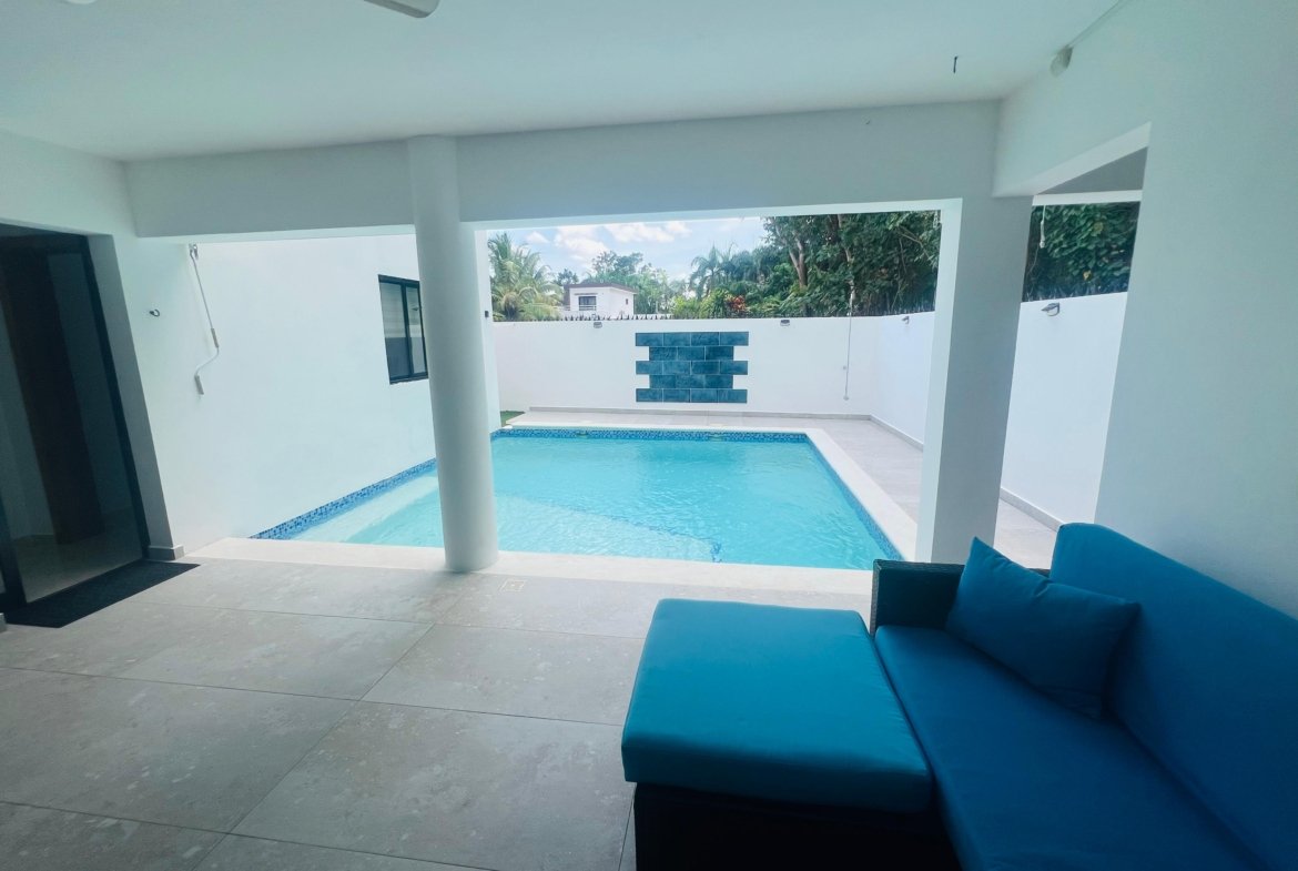 Piscina privada cubierta con sofá azul moderno