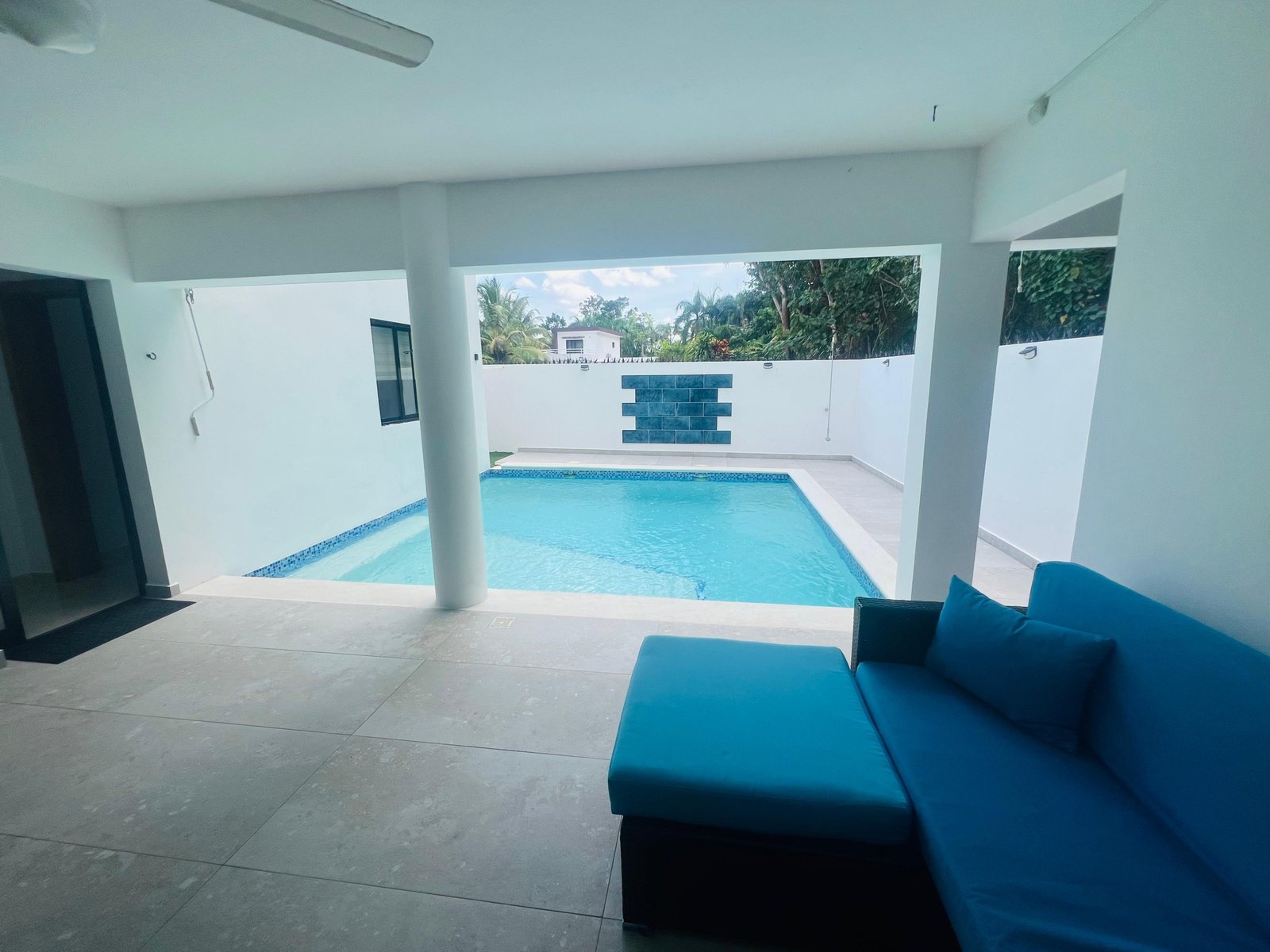 Piscina privada cubierta con sofá azul moderno