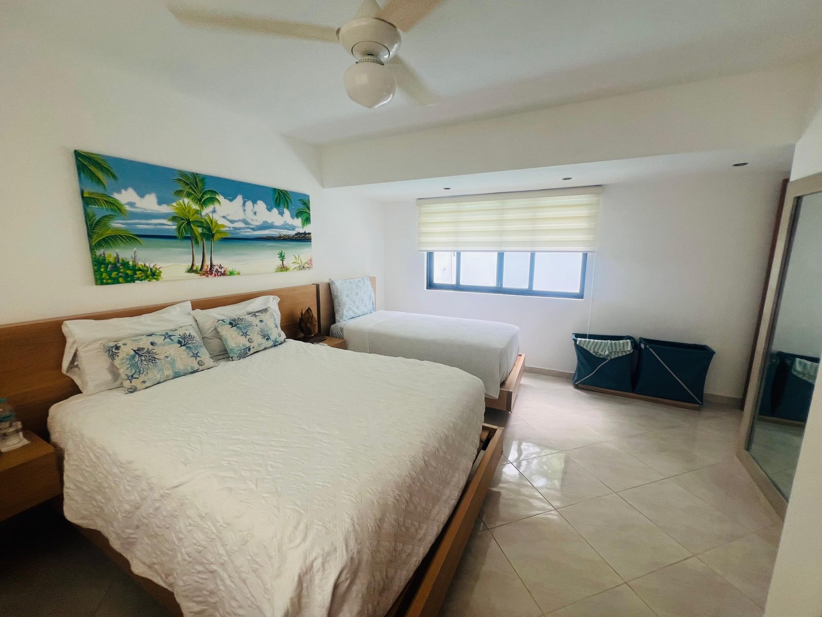 Dormitorio luminoso con cama doble y decoración tropical