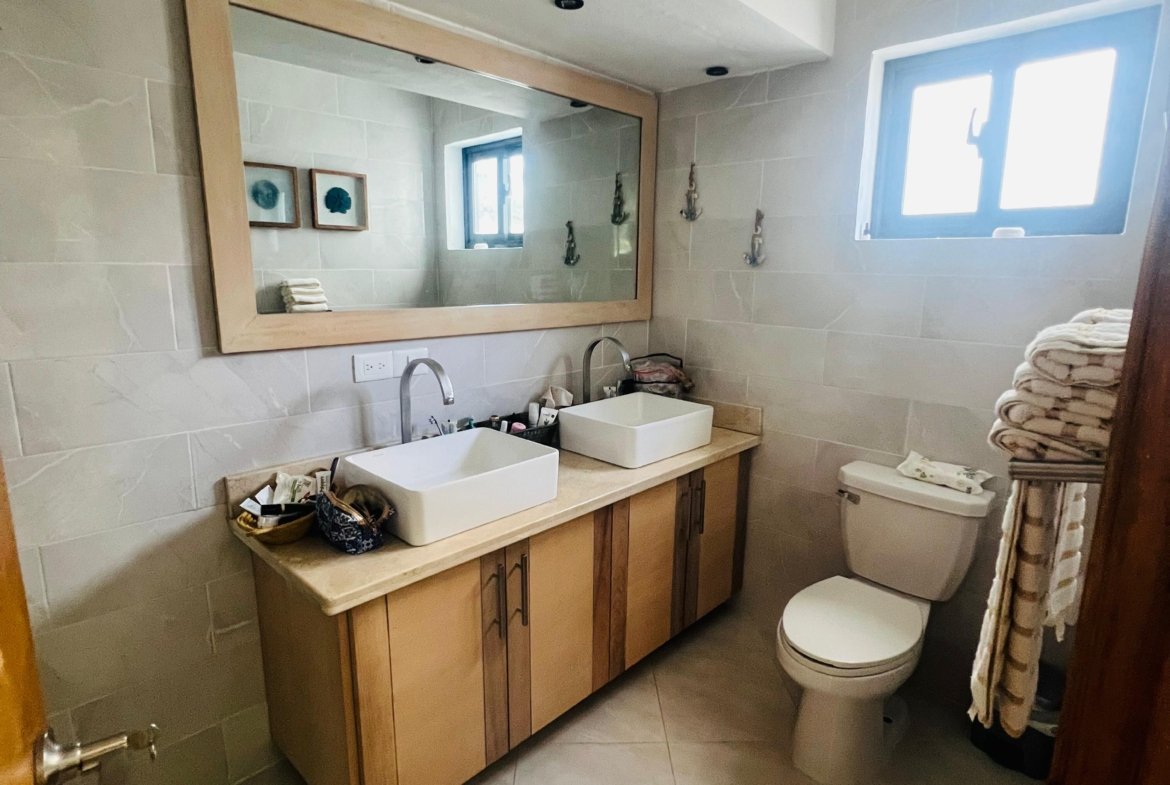 Baño moderno con doble lavabo y espejo grande