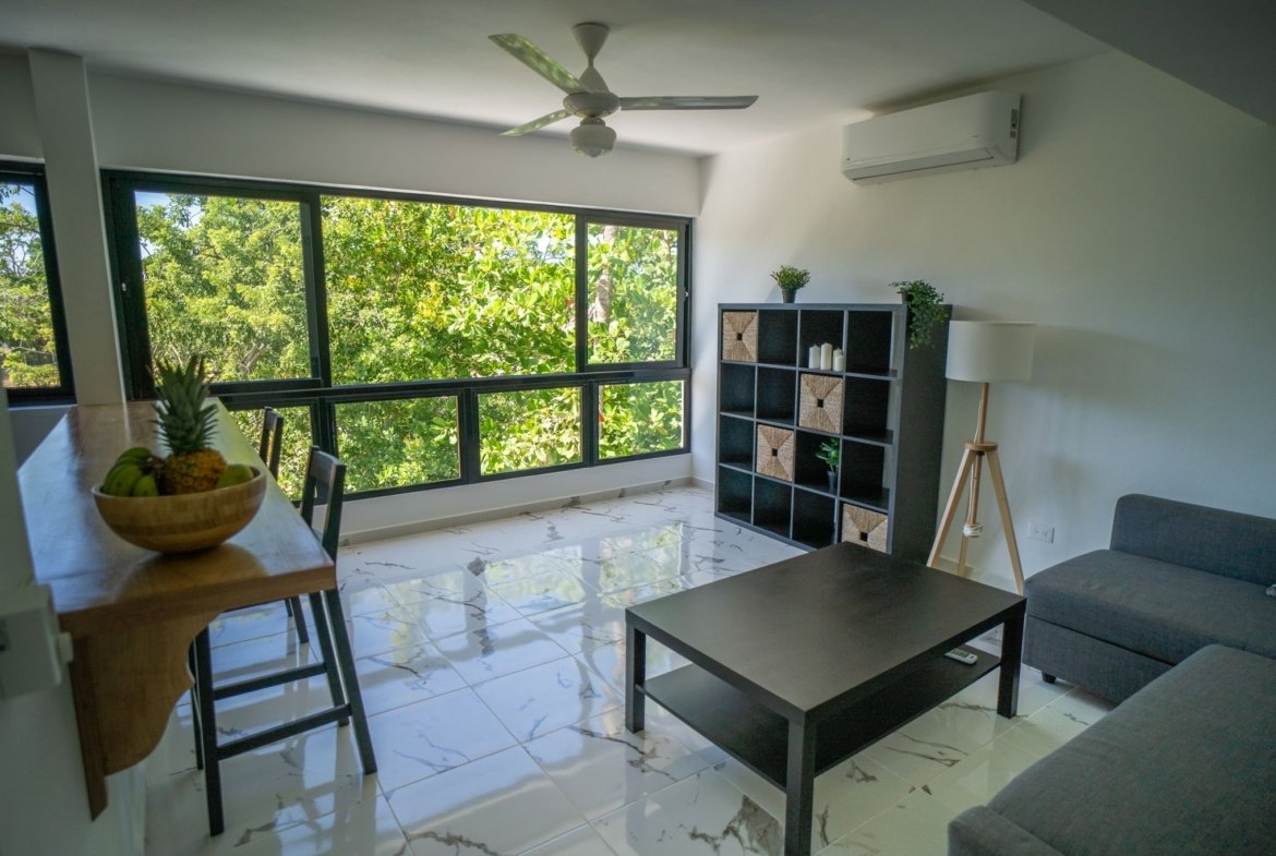 Salón moderno luminoso con grandes ventanales y vistas verdes