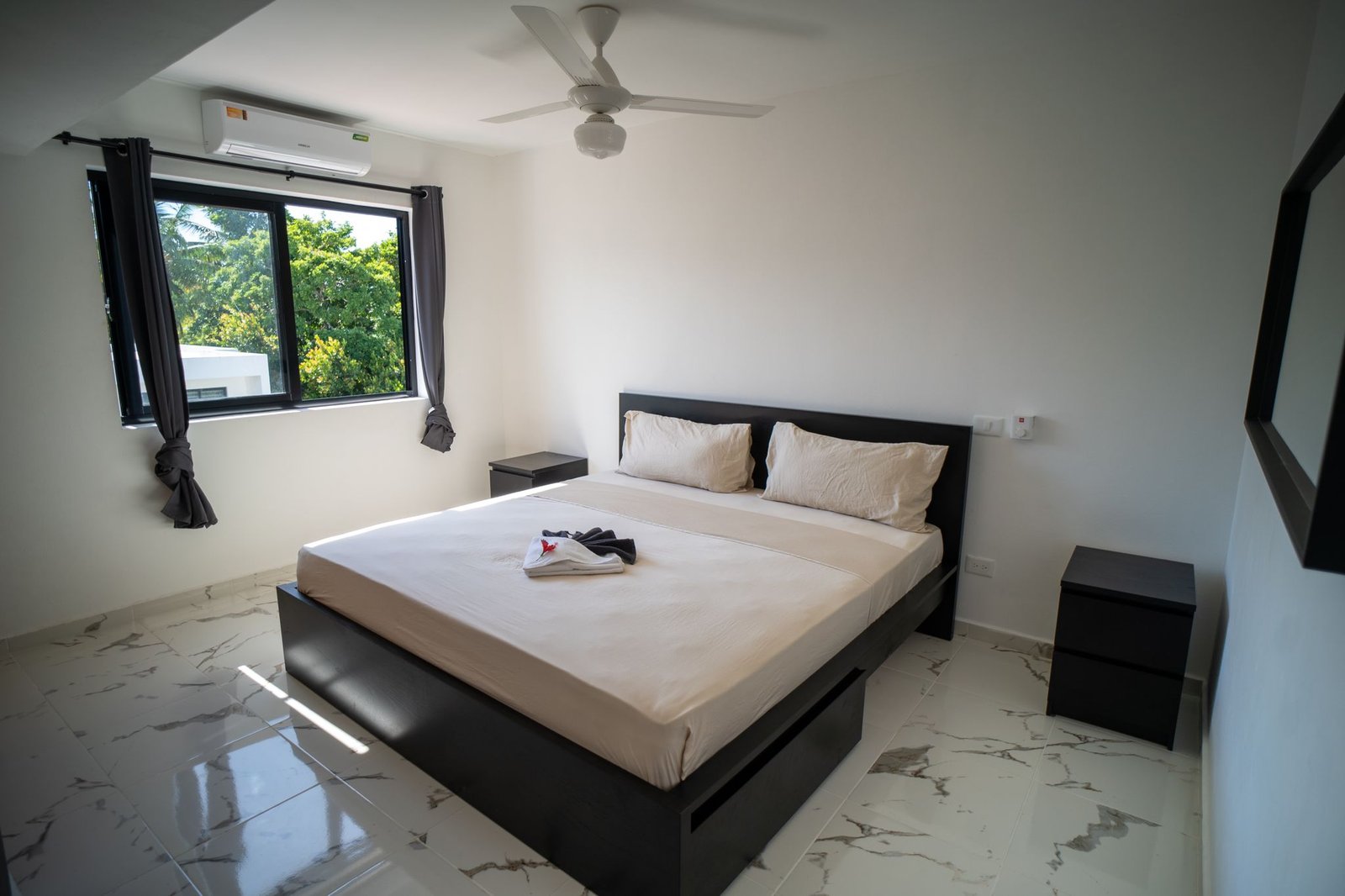 Dormitorio moderno con cama doble y ventana luminosa