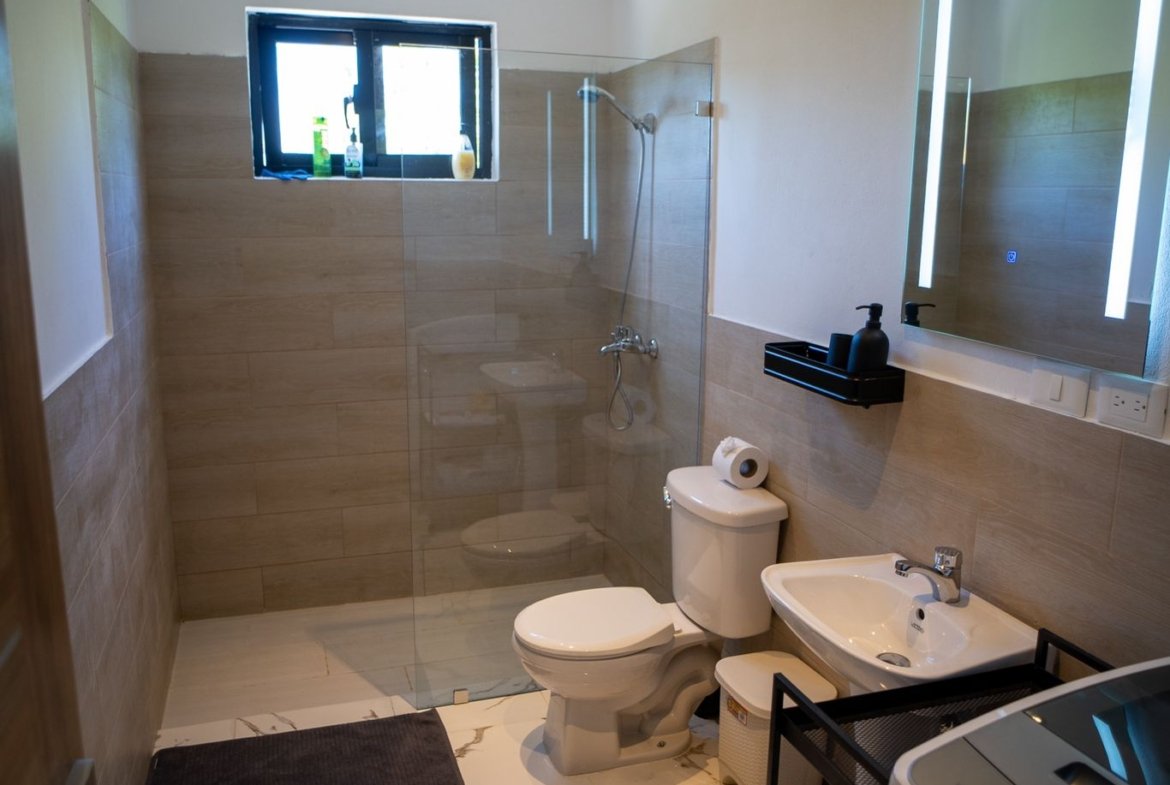 Baño moderno con ducha acristalada y lavabo