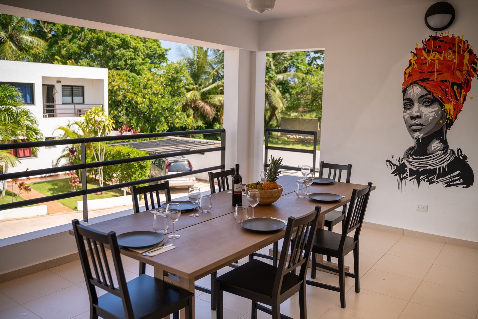 Comedor en terraza con mural y vista tropical