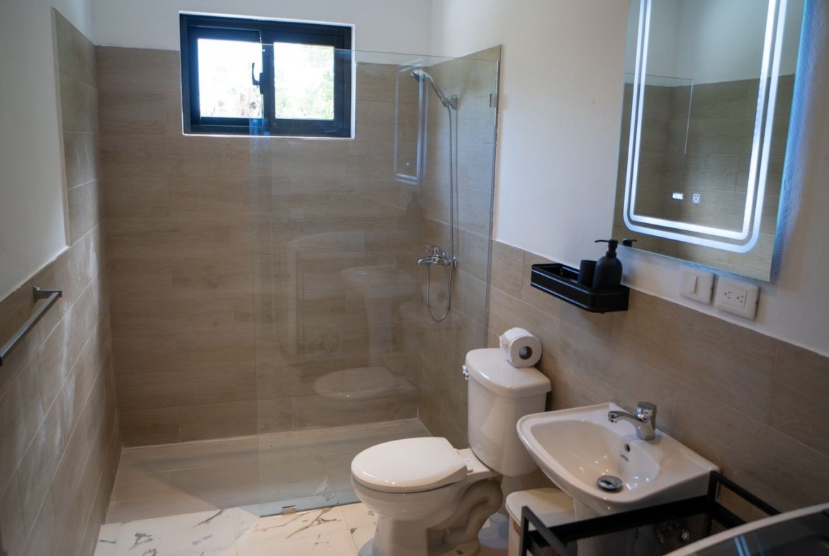 Baño moderno con ducha y espejo iluminado