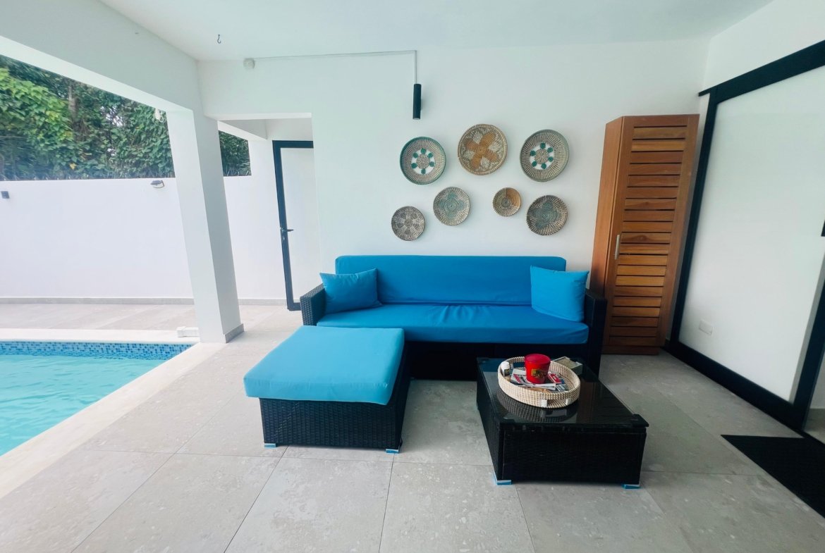 Terraza moderna con sofá azul junto a piscina