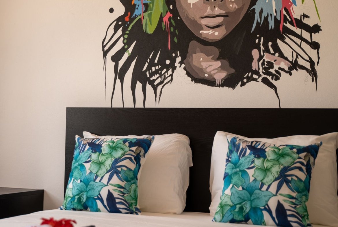Dormitorio con mural colorido sobre la cama