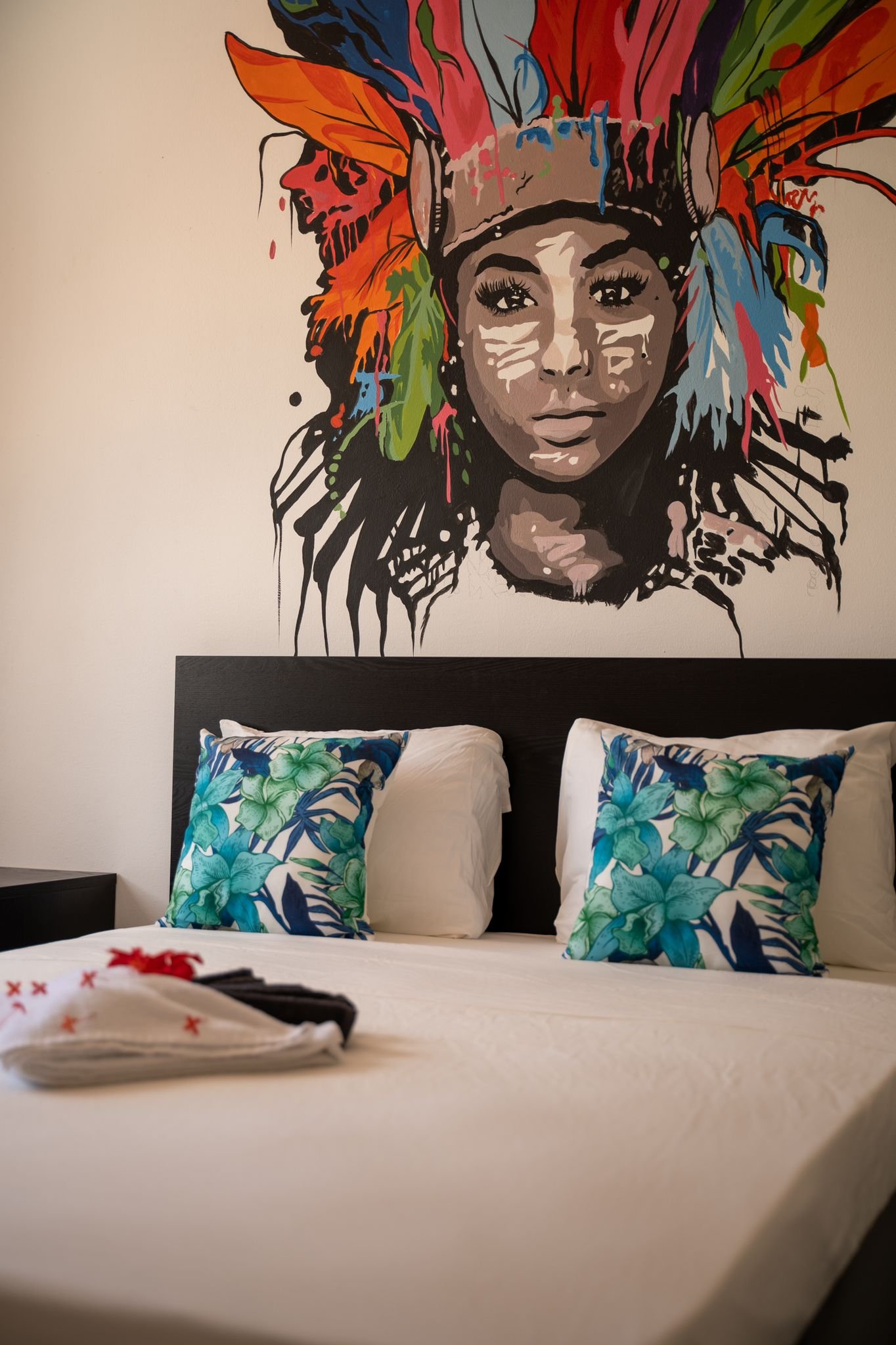 Dormitorio con mural colorido sobre la cama