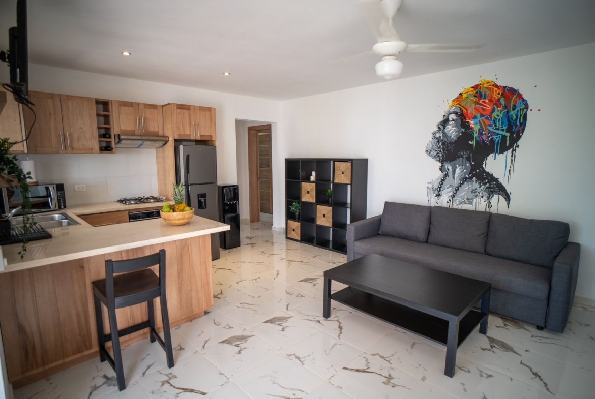 Salón moderno con cocina abierta y mural colorido