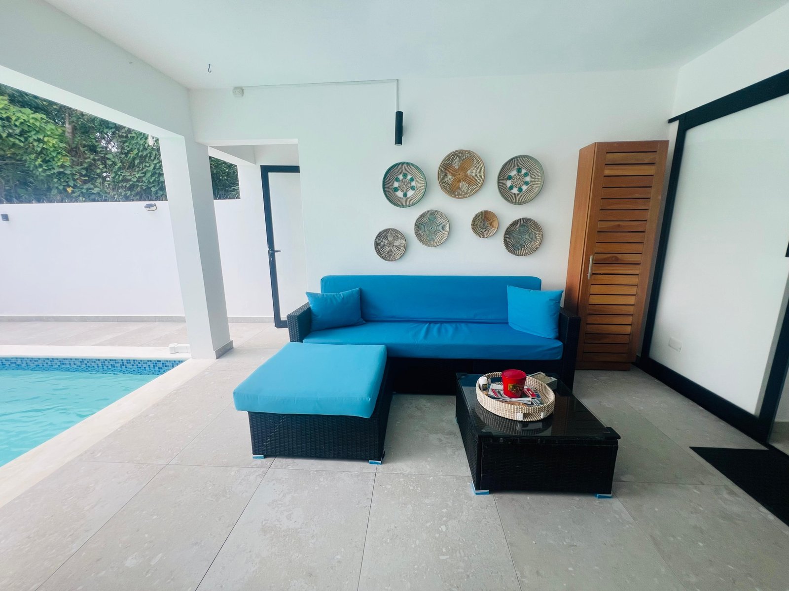 Terraza moderna con sofá azul junto a piscina