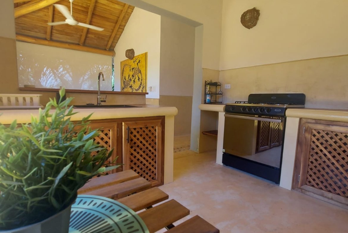 Cocina rústica con muebles de madera y ventilador