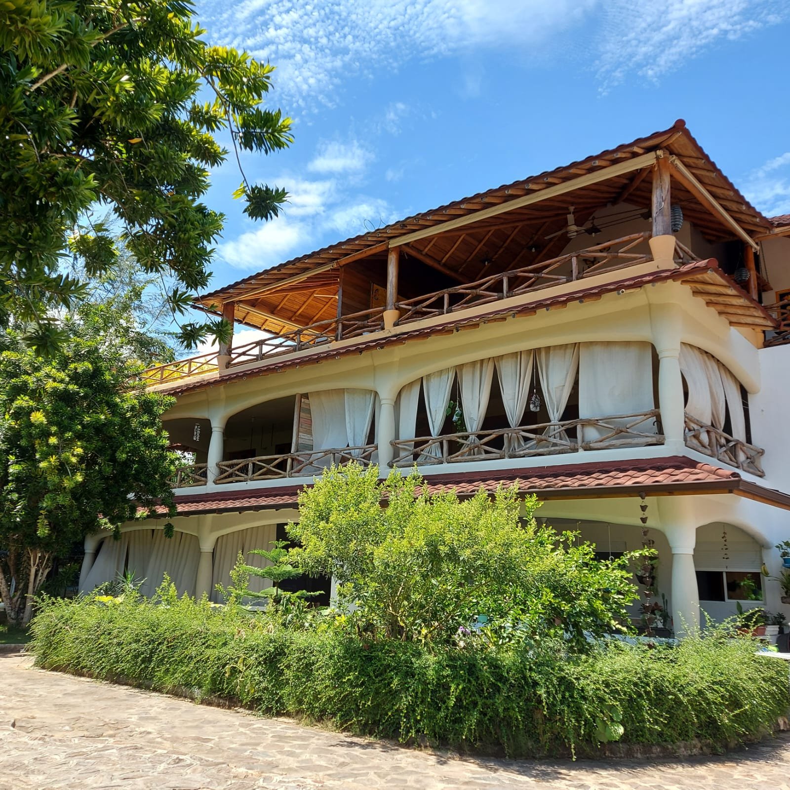 Maison tropicale avec balcons en bois et jardin