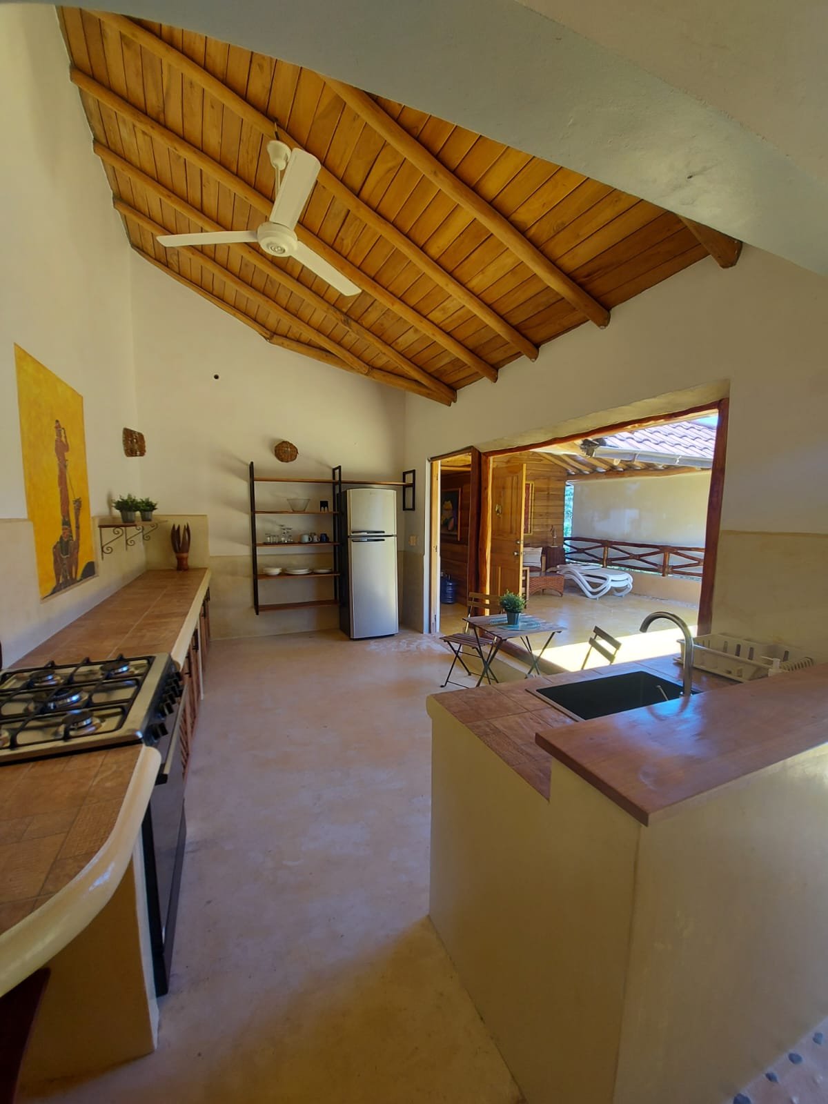 Cocina rústica con techo de madera y terraza