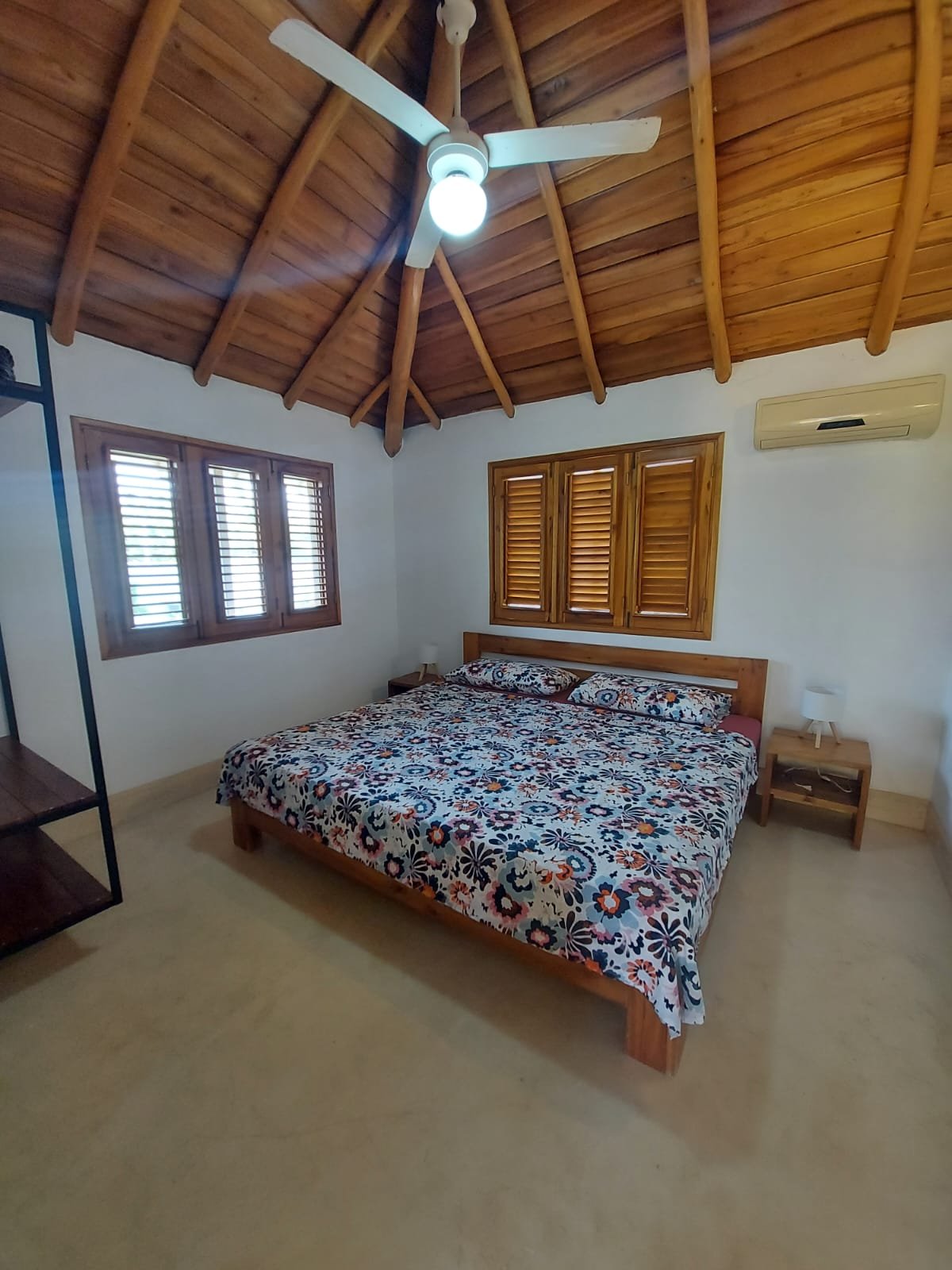 Dormitorio acogedor con techo de madera y ventilador