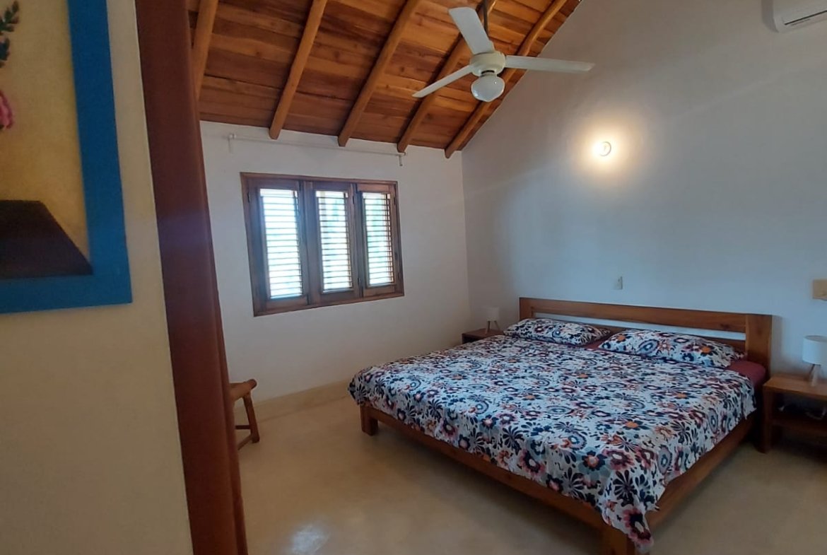 Dormitorio con cama doble y techo de madera