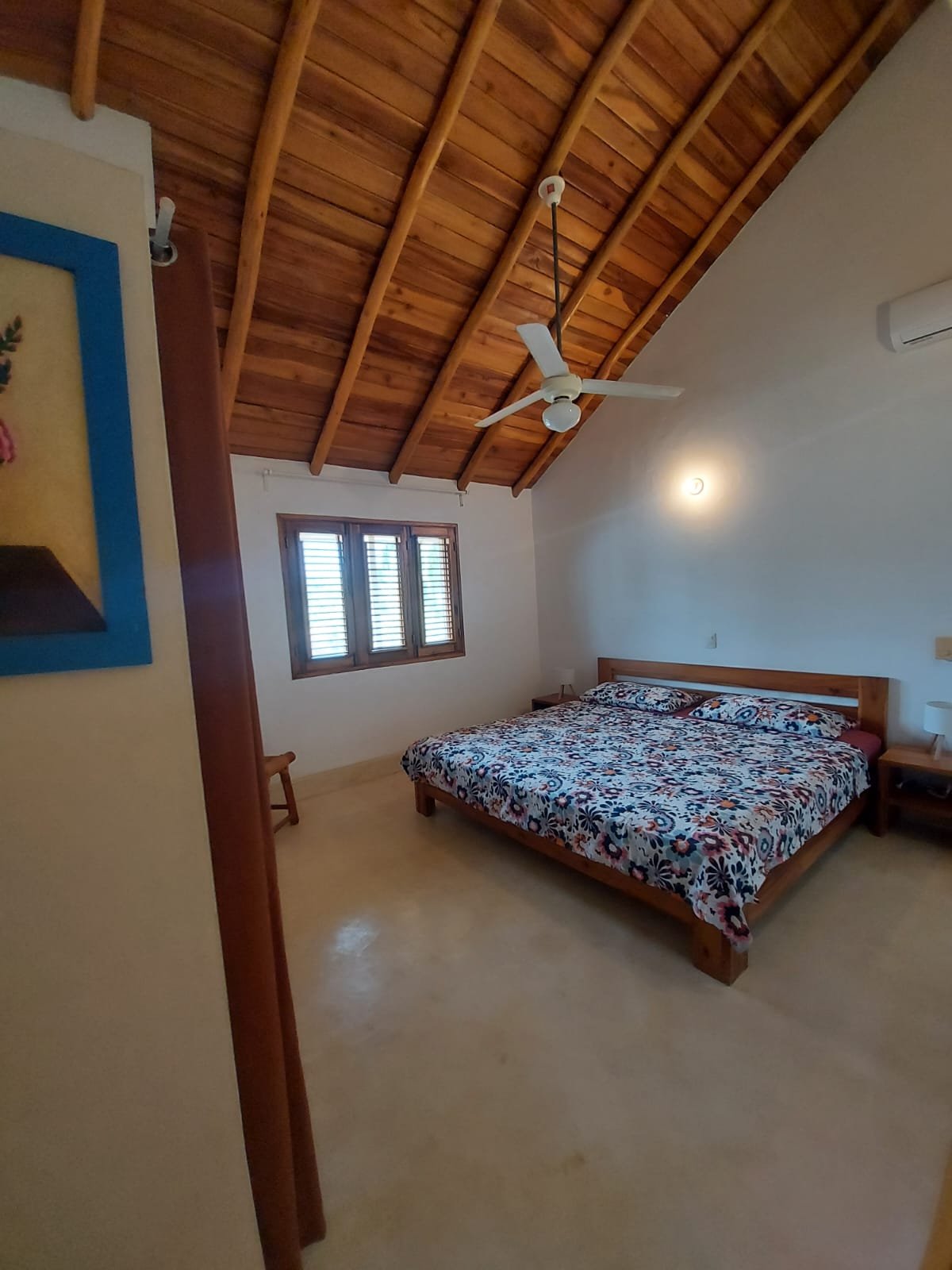 Dormitorio con cama doble y techo de madera