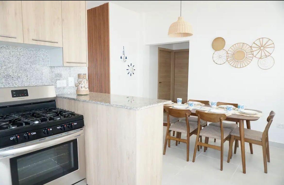 Cocina moderna con comedor de madera y encimera