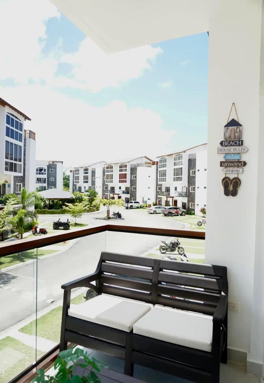 Apartamento En Popi (12) Balcón con banco frente a apartamentos modernos