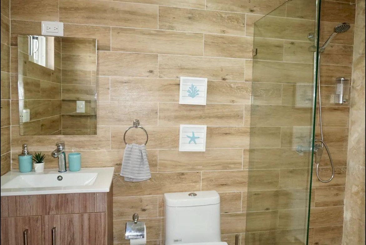 Baño moderno con ducha acristalada y azulejos efecto madera