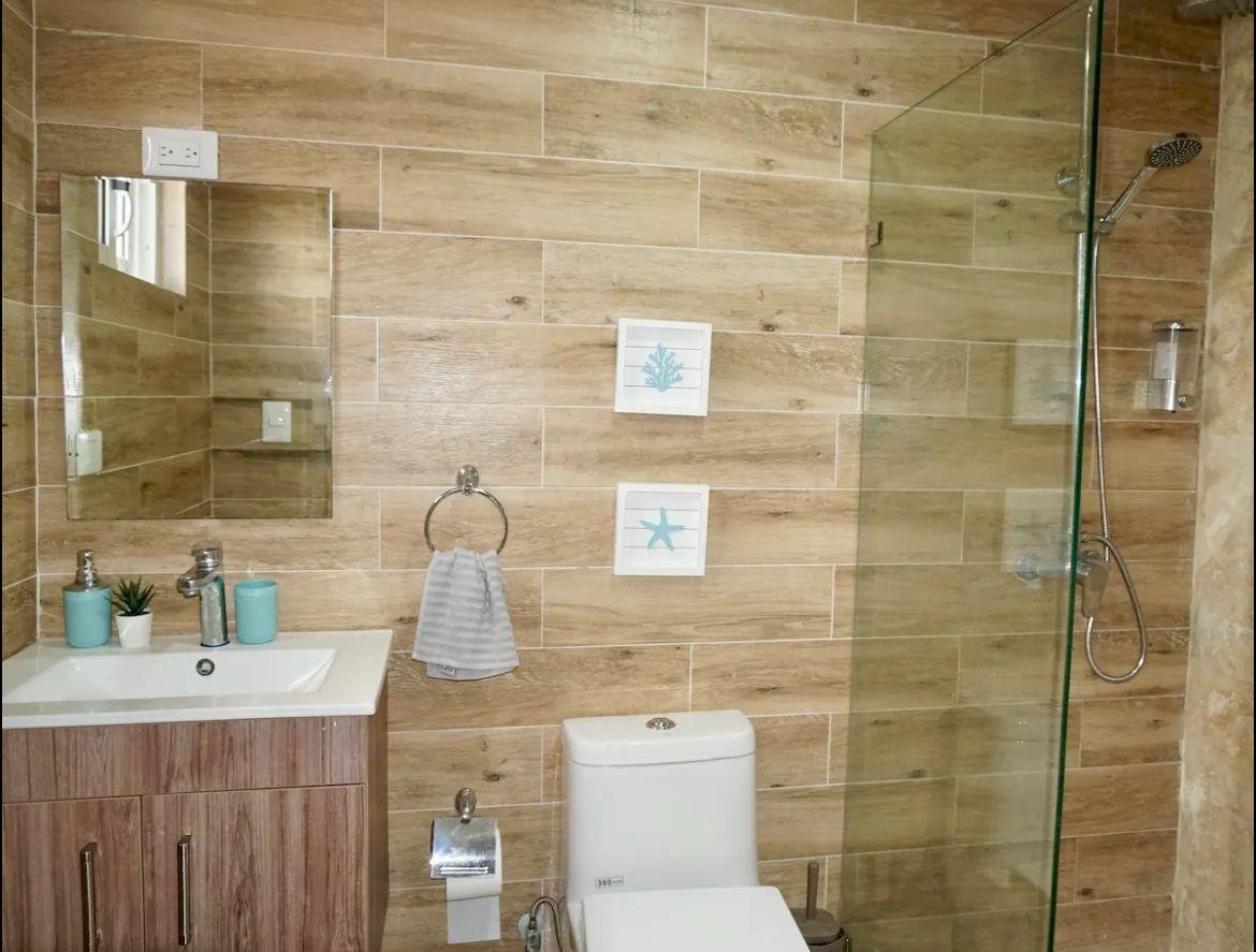 Apartamento En Popi (14) Baño moderno con ducha acristalada y azulejos efecto madera