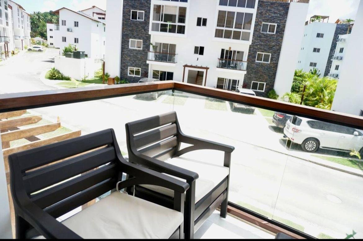 Balcón moderno con sillas y vista residencial