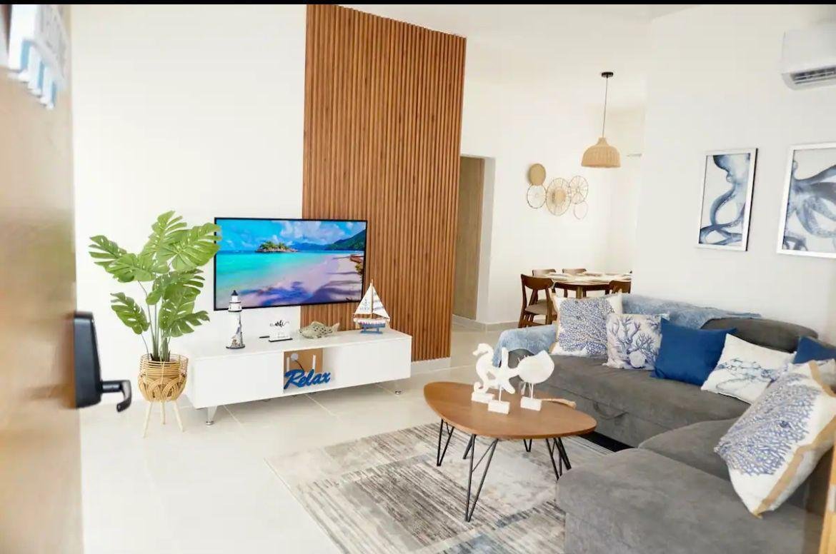 Salón moderno con sofá gris y panel de madera