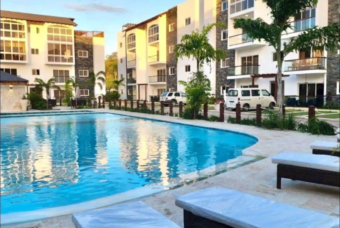 Piscina en complejo residencial moderno con palmeras