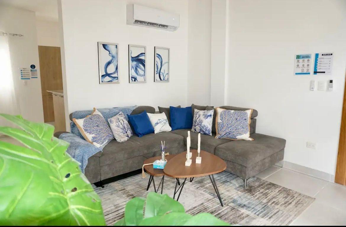 Salón moderno con sofá gris y cojines azules