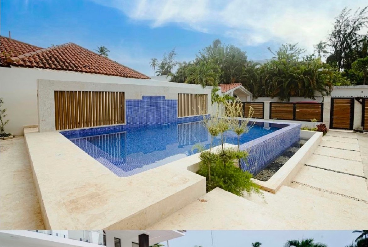 Piscina infinita moderna junto a casa blanca