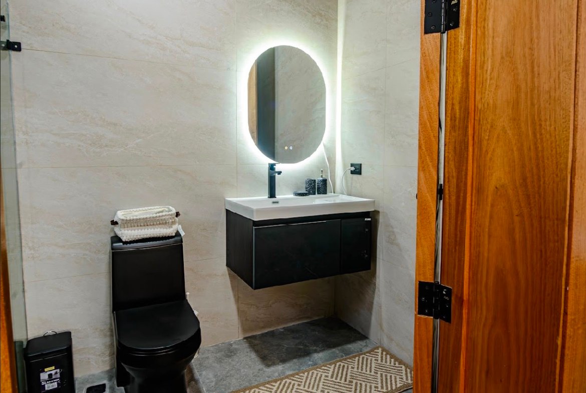 Baño moderno con lavabo flotante y espejo iluminado