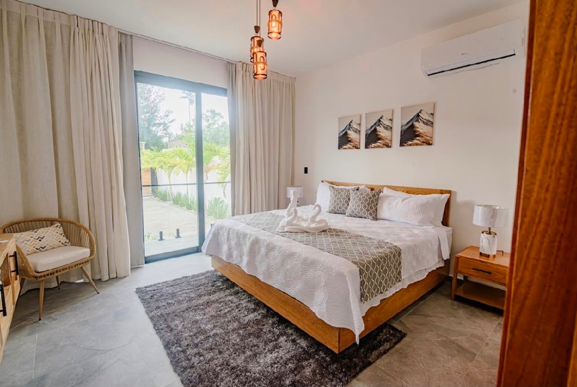 Dormitorio moderno con cama grande y terraza luminosa