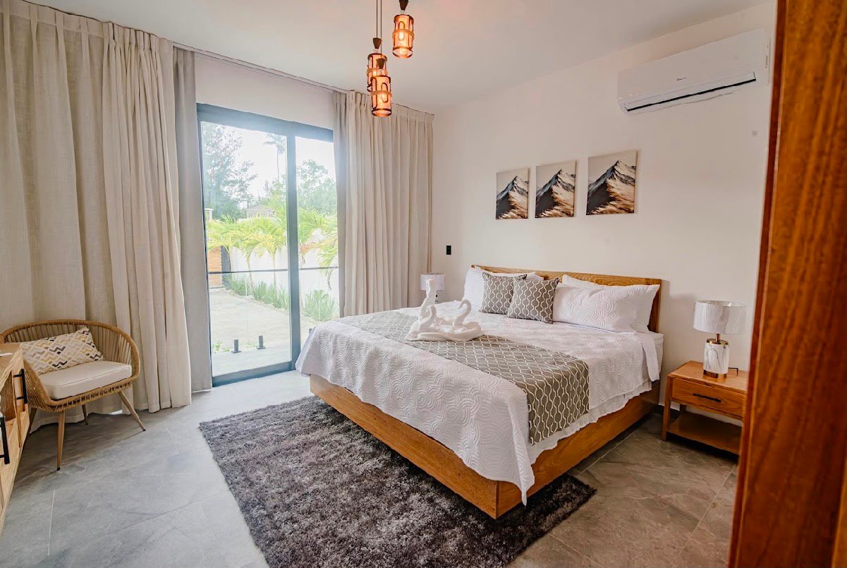 Dormitorio moderno con cama grande y terraza luminosa