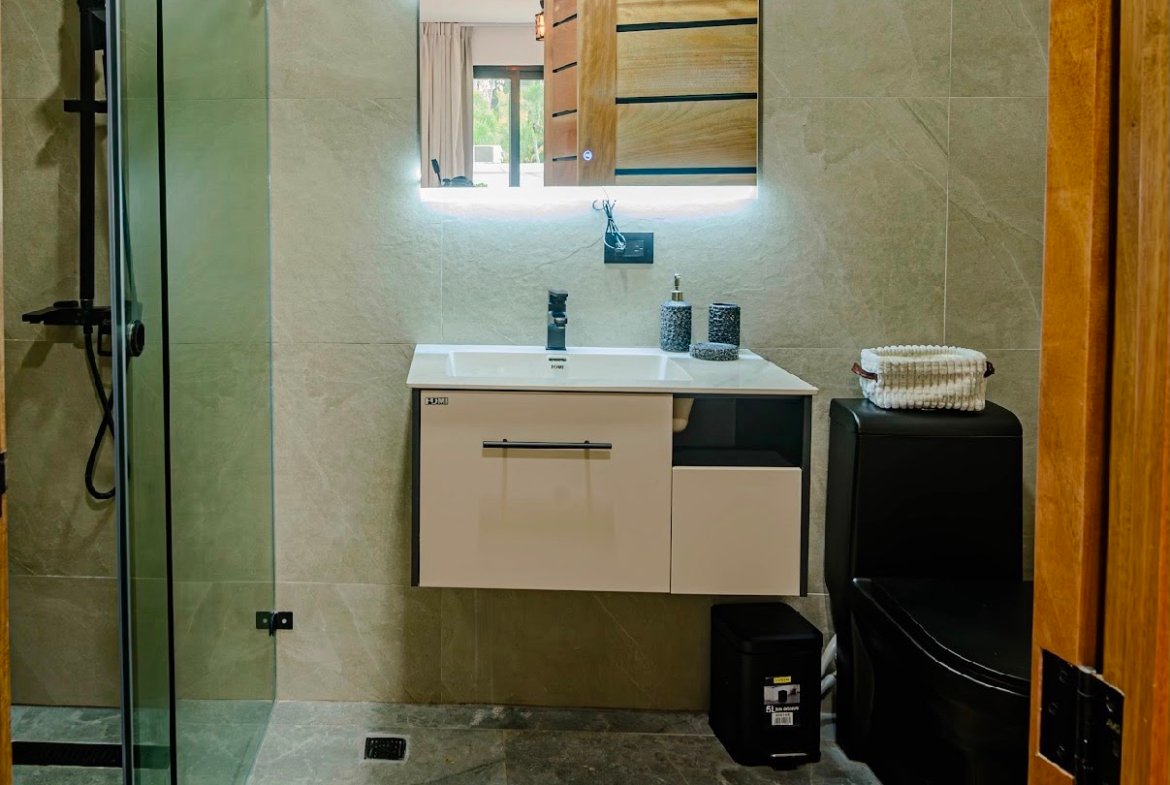 Baño moderno con ducha acristalada y espejo iluminado