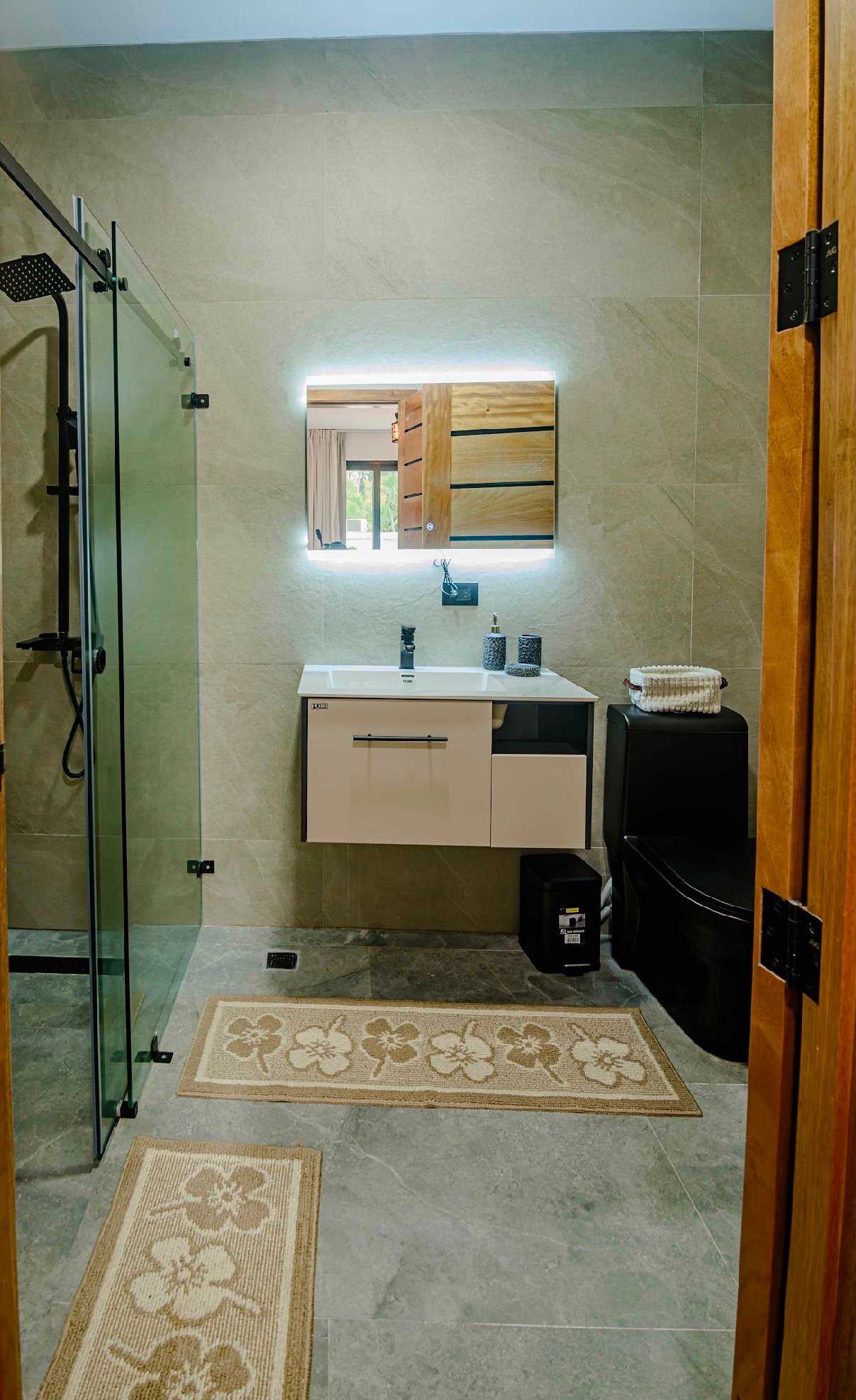 Baño moderno con ducha acristalada y espejo iluminado