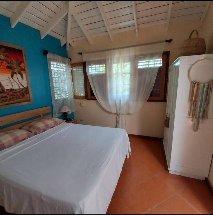 Dormitorio luminoso con cama blanca y paredes azules